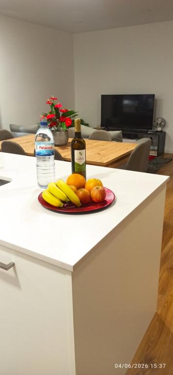 a plate of fruit and a bottle of wine on a counter at T1 Luxgarden in Lamego