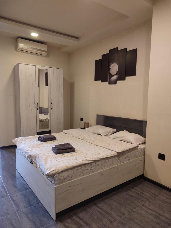 a bedroom with a large bed with two towels on it at Sani Hotel Yerevan in Yerevan