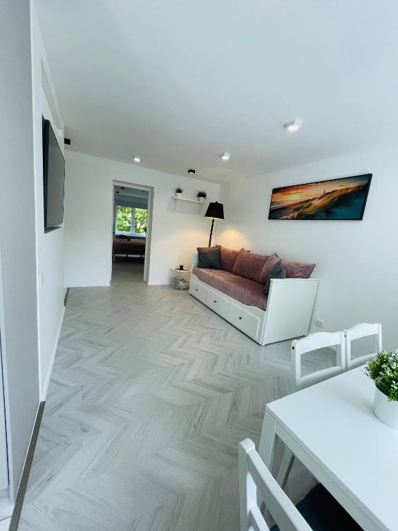 a living room with a couch and a table at White Apartment in Liepāja