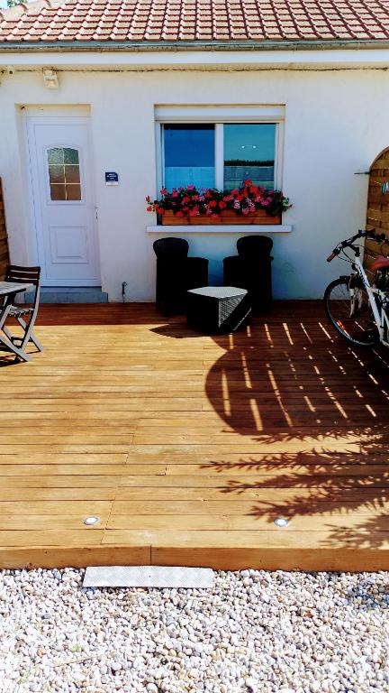 a patio with a table and a window with flowers at gite repos et tranquillité P in Cayeux-sur-Mer