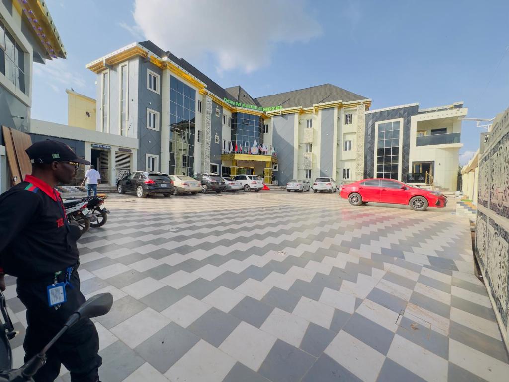 a man on a scooter in a parking lot at Don Marble Hotel And Suites in Auchi