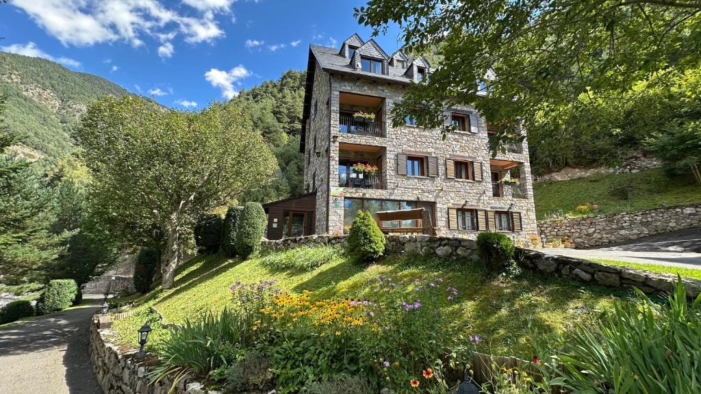 a stone house on a hill with a garden at Apartaments la Peguera in Bohí