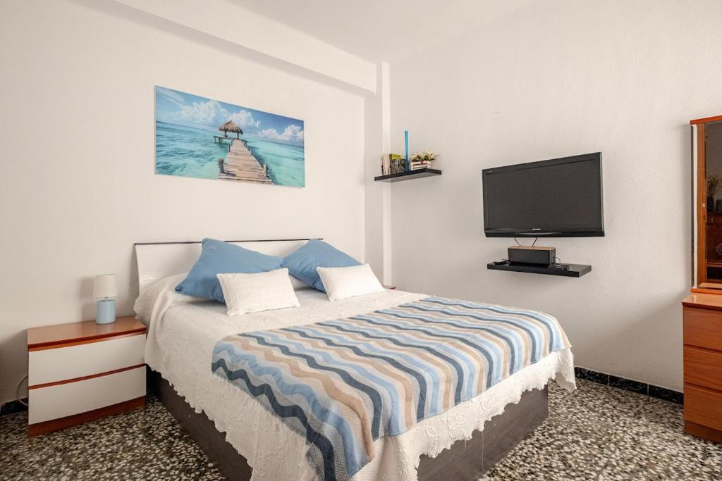 a bedroom with a bed and a flat screen tv at Piso DE-MI-LA in Aspe