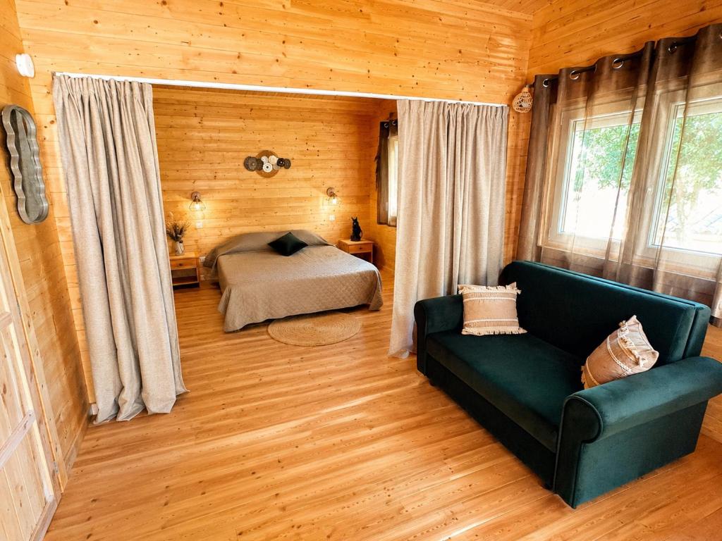 a bedroom with a bed and a couch in a room at Chalet Chêne-Pin in Boutenac