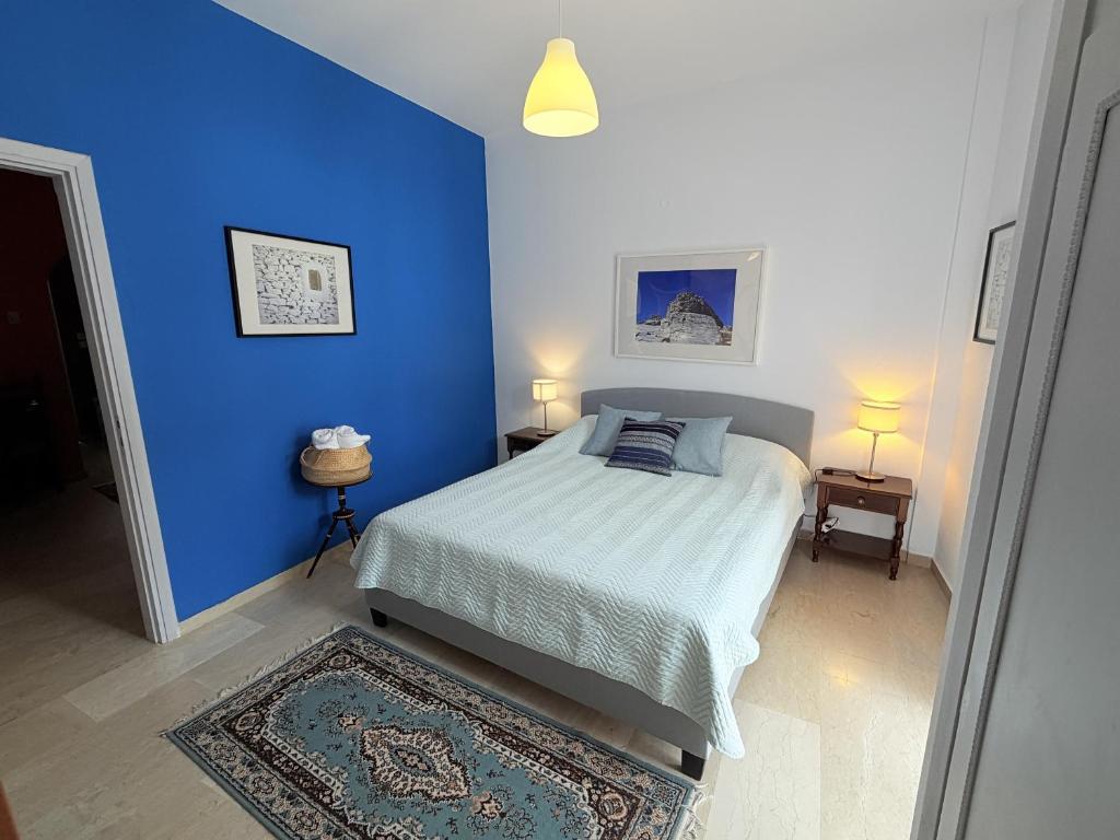 a blue bedroom with a bed and a blue wall at Art & Motion Union - Guest Room 4 in Andros