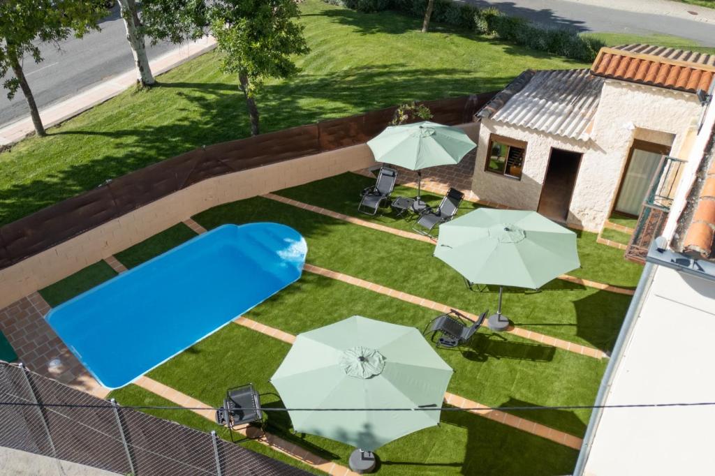 an aerial view of a backyard with a pool and umbrellas at La Casita de Lucia in Trescasas
