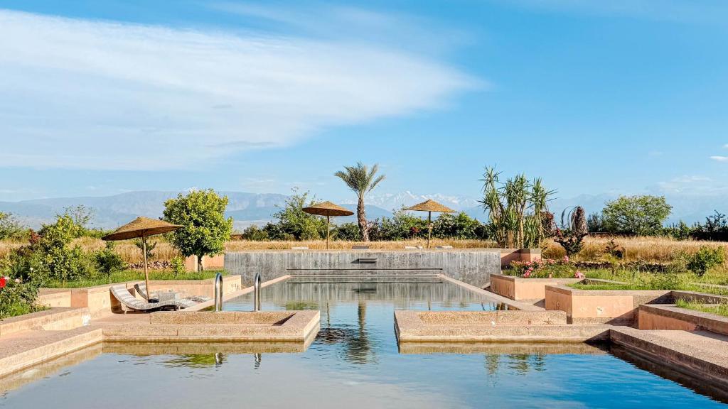 a swimming pool in the middle of a house at Villa TIGMIZEN - 10CH - Piscine chauffée et Spa - Marrakech in El Aouina