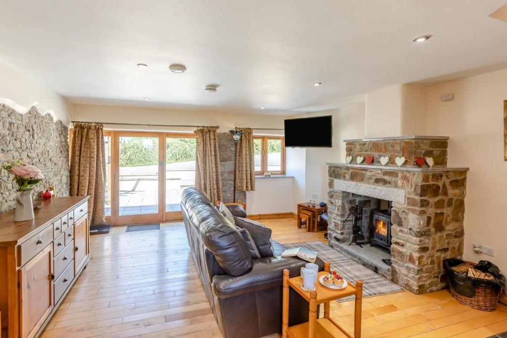 a living room with a couch and a fireplace at 1 Bed in Bideford oc-labdr in Woolfardisworthy