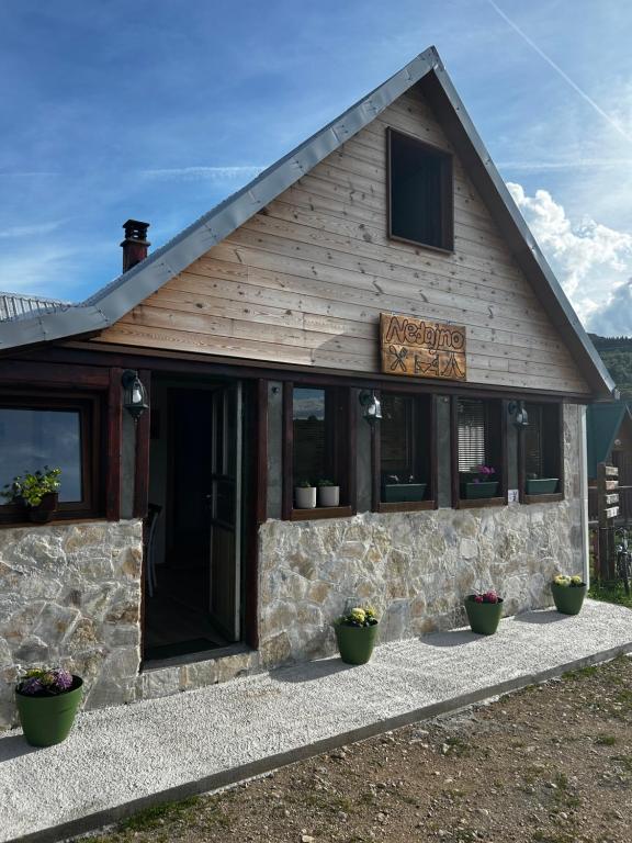 a building with windows and plants in front of it at Guesthouse Nedajno in Nedajno