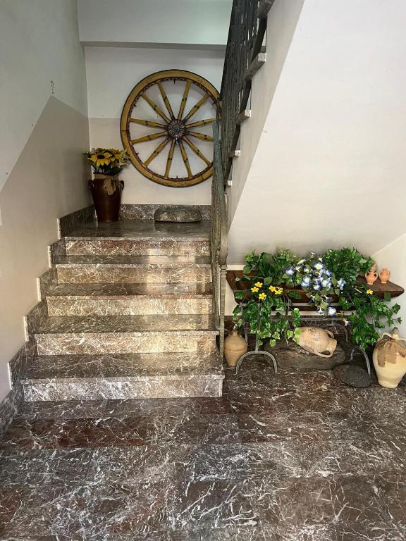 a stairway with flowers and a clock on the wall at I Pantani in Schisò