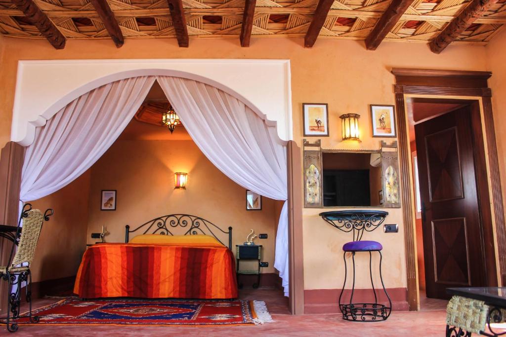 a bedroom with a bed with a red blanket at Dar Amoudou in Ouarzazate