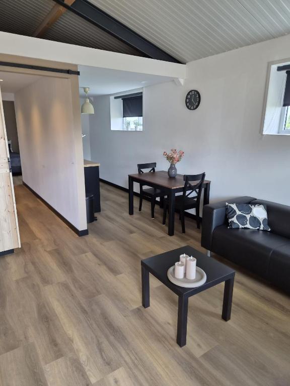 a living room with a couch and a table at Bed&Boerderij De Veldmuis in Eemdijk