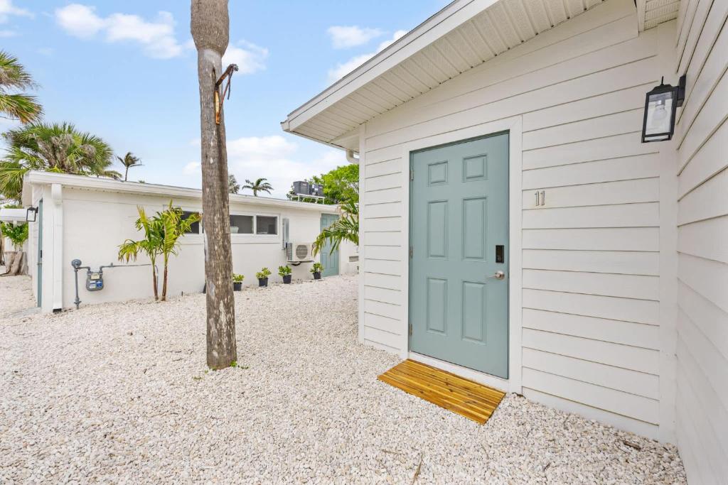 a white building with a blue door at Breakwater Bungalow in Cocoa Beach