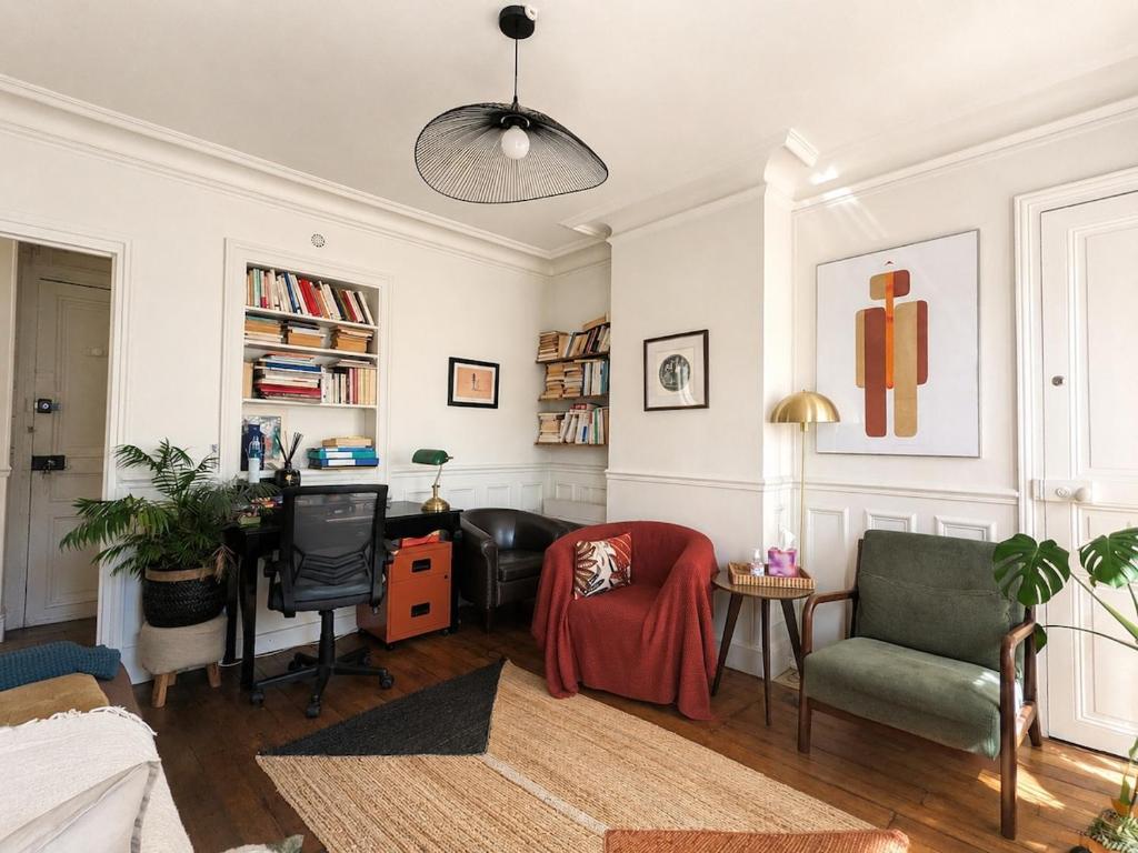 a living room with a couch and a desk at Charmant appartement au cœur de Paris in Paris