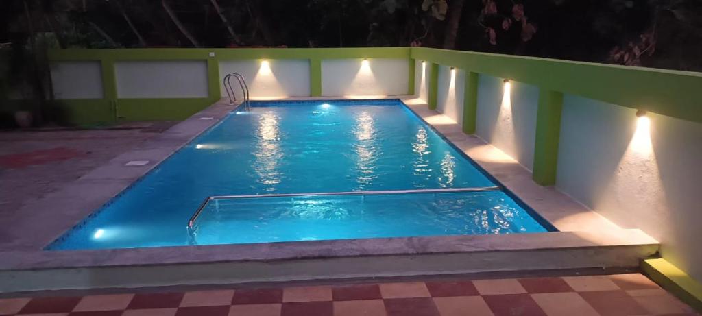 a swimming pool at night with lights on it at FM Villa Auroville in Pondicherry