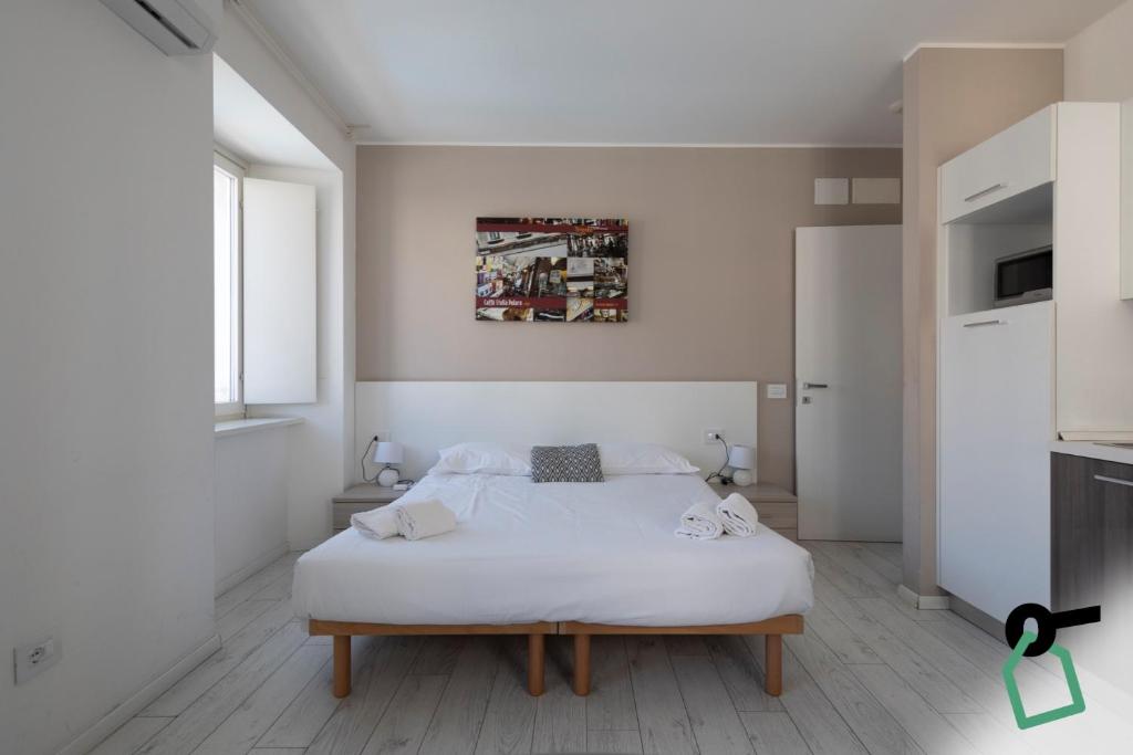 a white bedroom with a bed in a room at Hotiday Trieste Corso Italia in Trieste