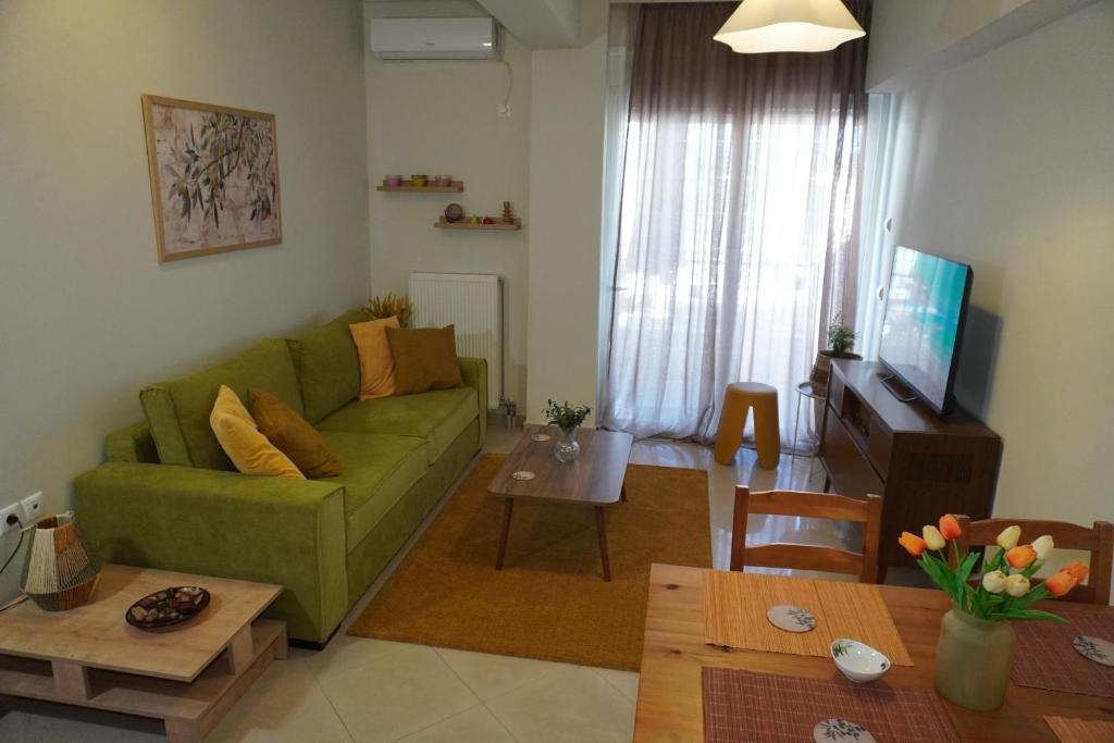 a living room with a green couch and a table at Anelia in Nea Artaki