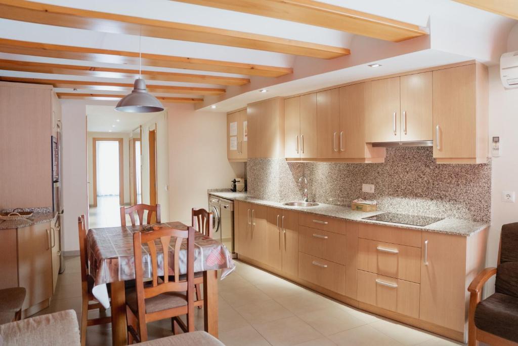 a kitchen with a table and a dining room at Apartaments Ca L'Albert in La Pobla de Segur
