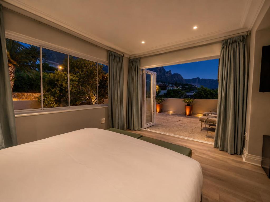 a bedroom with a bed and a large window at Vetho Villa in Cape Town