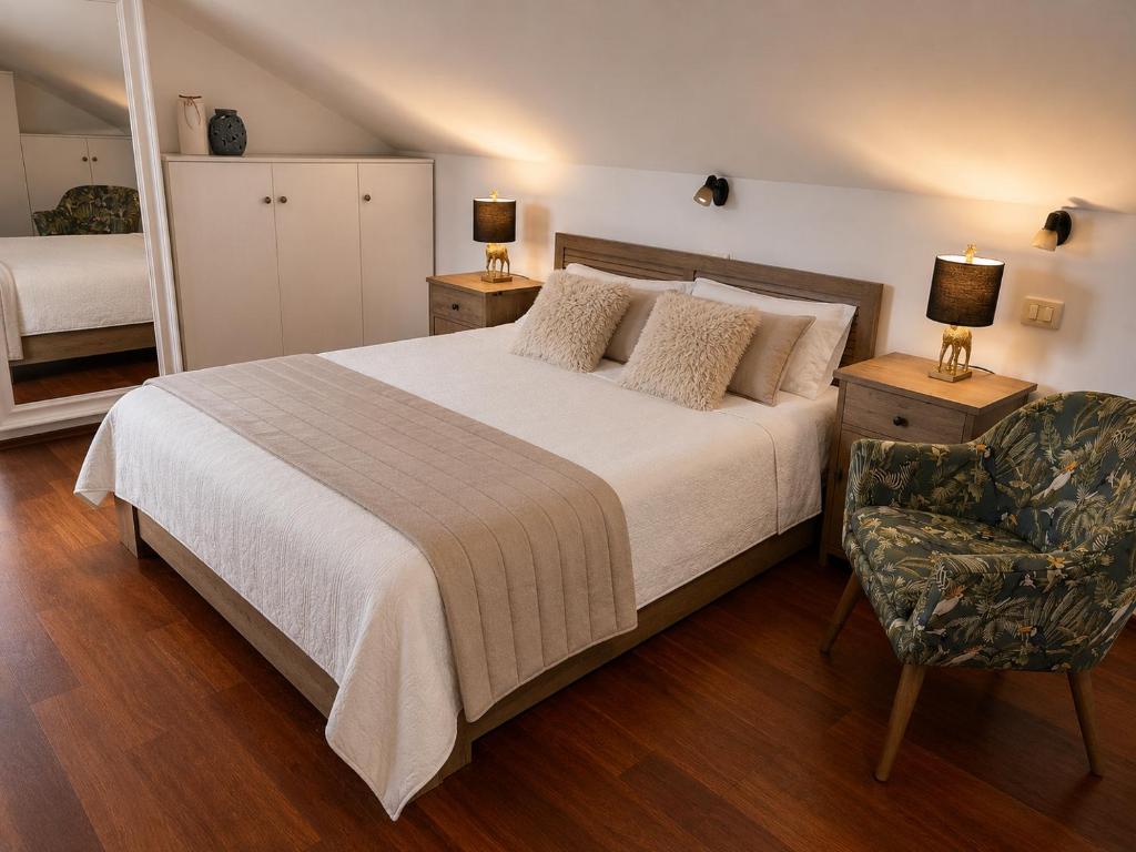 a bedroom with a large bed and a chair at Villa Magnetic in Baošići