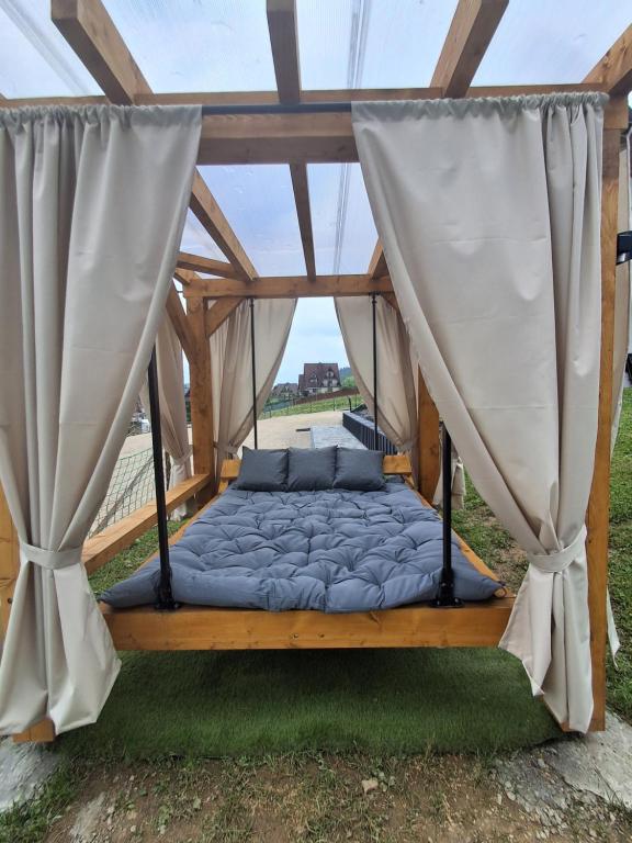 a bed in a gazebo with curtains at Domki nad Borem in Małe Ciche