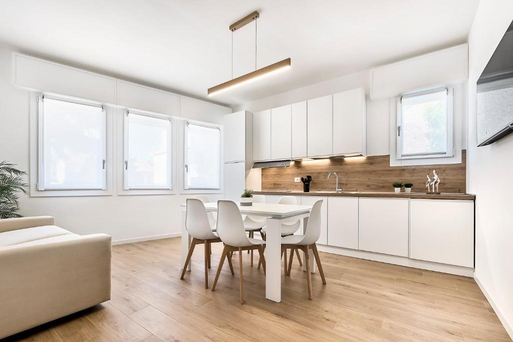 a kitchen and dining room with a table and chairs at Sand Beach House - Host Solution in Cavallino-Treporti