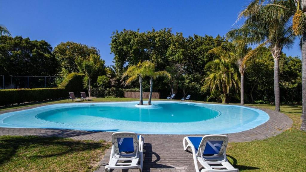 a pool with two lounge chairs and a poolurity at yalwa house in Sweet Valley