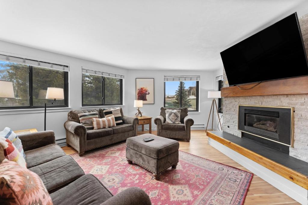 a living room with a fireplace and a flat screen tv at Plaza #1404 in Keystone