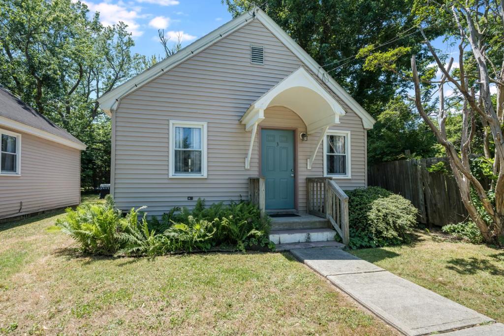 a house with a blue door and a yard at Chris Cottage 3 in Chincoteague