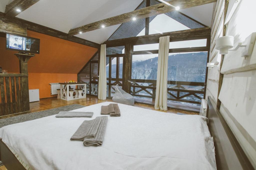 ein großes Bett in einem Zimmer mit einem großen Fenster in der Unterkunft Guculka Apartments in Jaremtsche