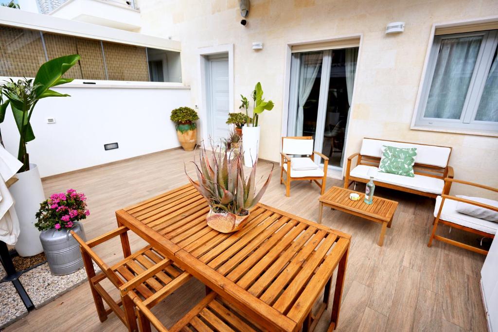 a patio with a wooden table and chairs at Casa Federica by MOH in Grottaglie