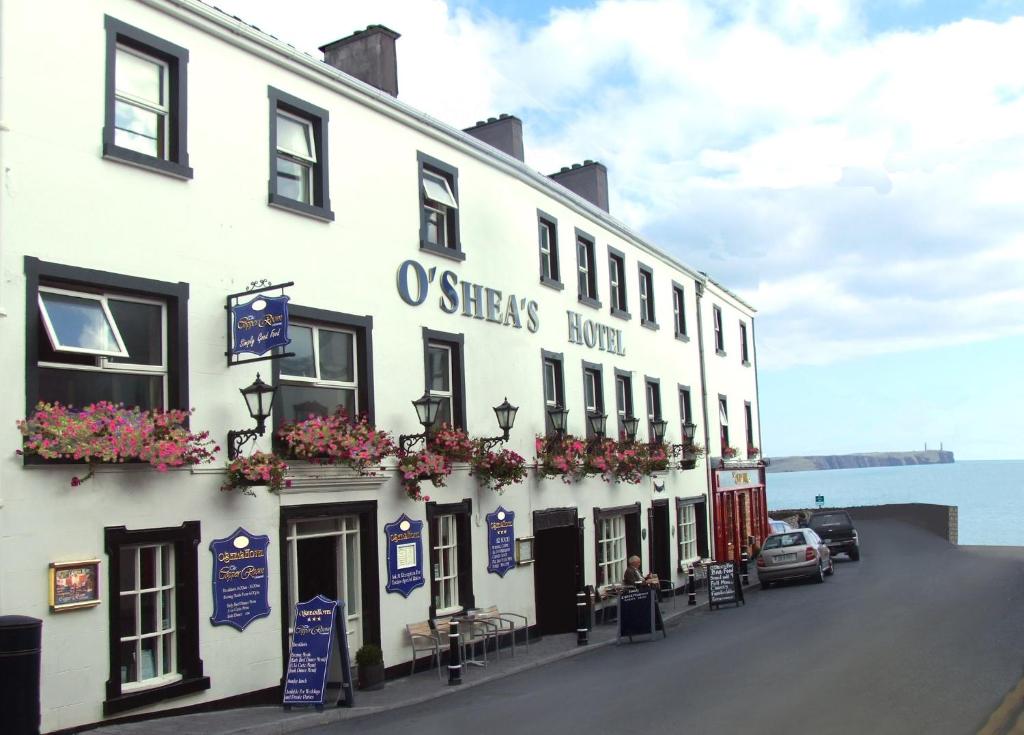 un edificio blanco con flores a un lado en O'Shea's Hotel en Tramore