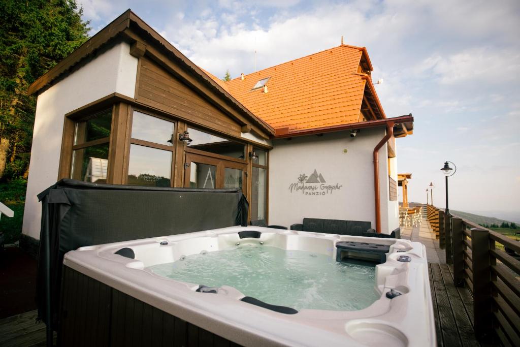 a hot tub in the backyard of a house at Madarasi Gyopár Panzió in Izvoare
