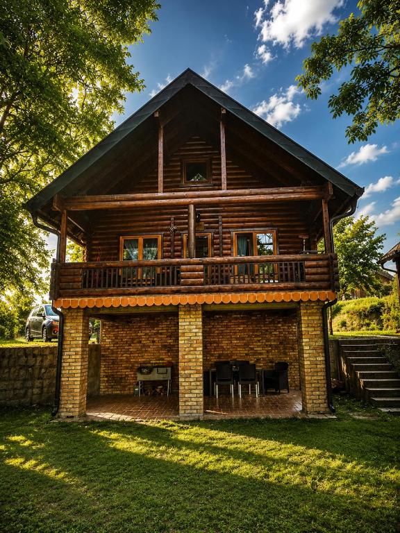 a log cabin with a deck on a lawn at Drinka in Ljubovija