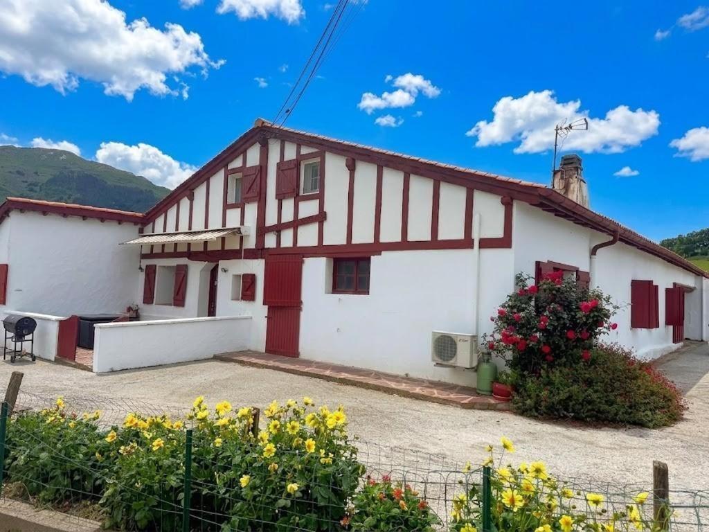 a white and red building with flowers in front of it at Axuri-alde in Sare