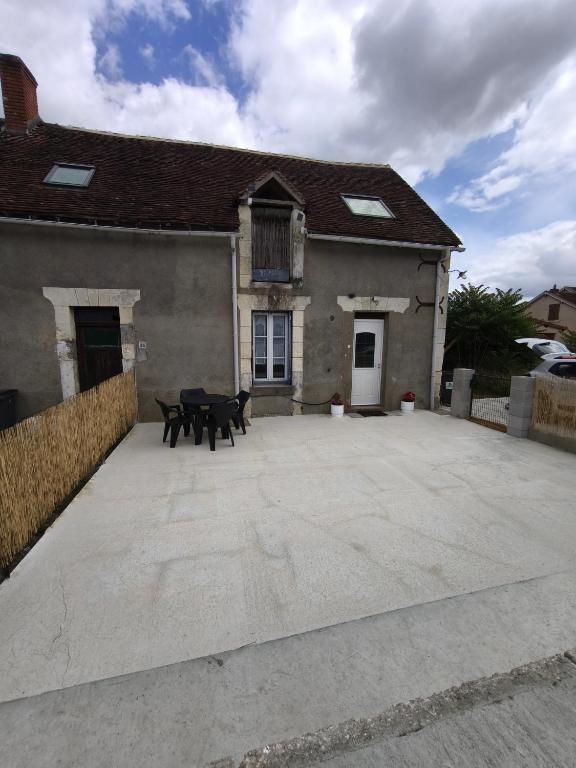 a house with two benches in front of it at la longère du moulin in Noyers-sur-Cher