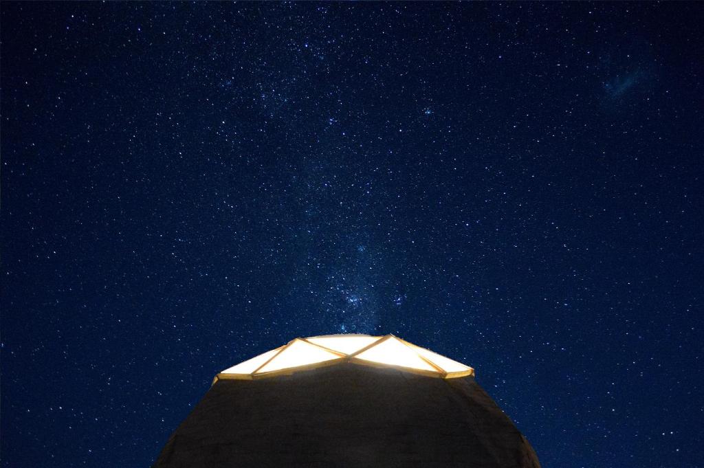 a light in the middle of a night sky with stars at Hotel Observatorio TukunMapu in Vicuña