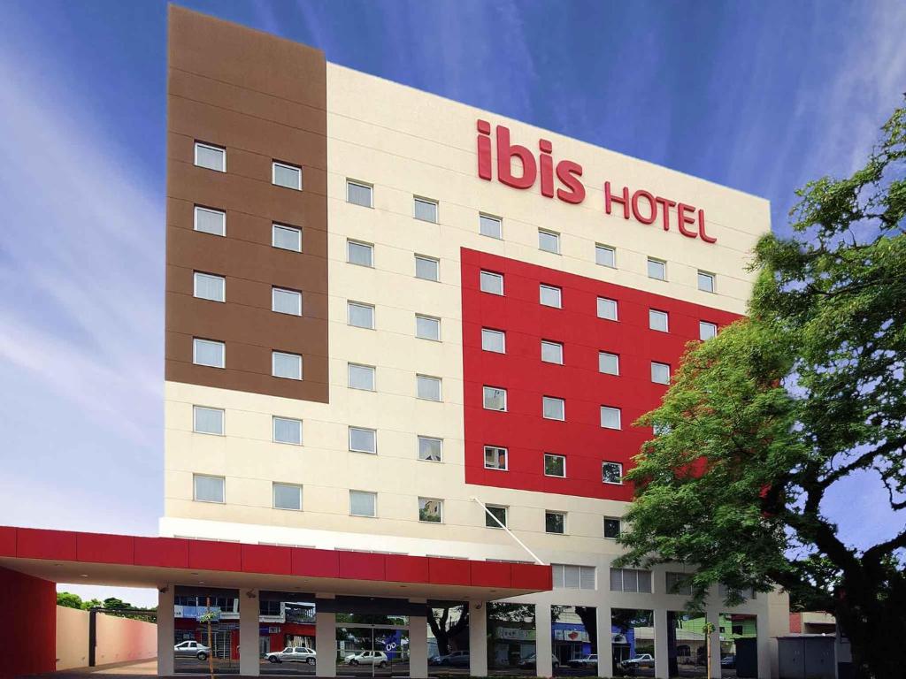 a big building with a big red hotel at ibis Cascavel in Cascavel