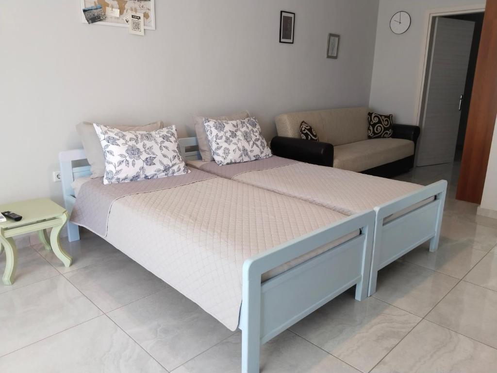 a large bed in a room with a couch and a table at Central and tranquil in Kavála