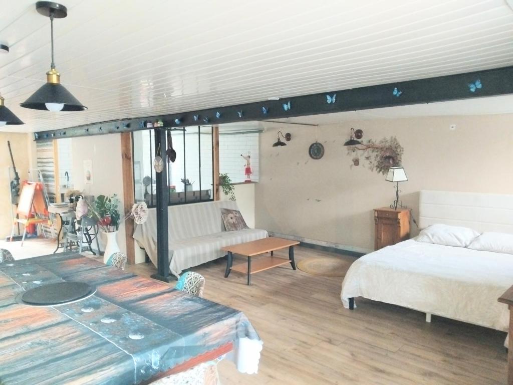 a living room with two beds and a couch at Studio calme avec billard in Saint-Priest