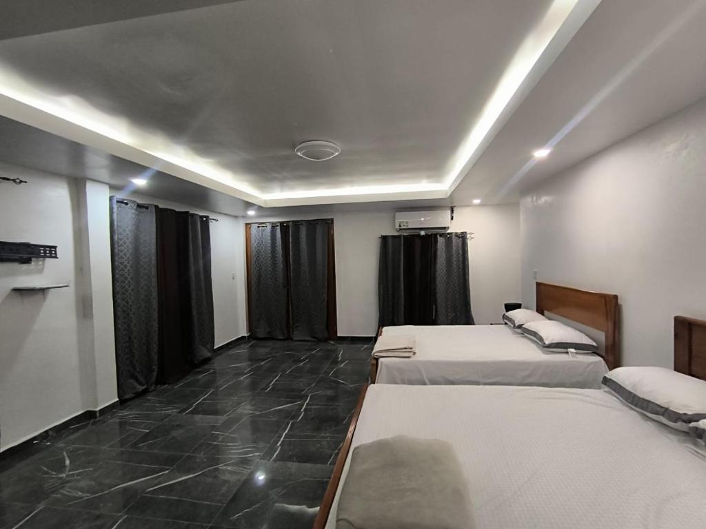 a room with three beds in it with black curtains at Frontera Stay Don Pinto in Canoa Abajo