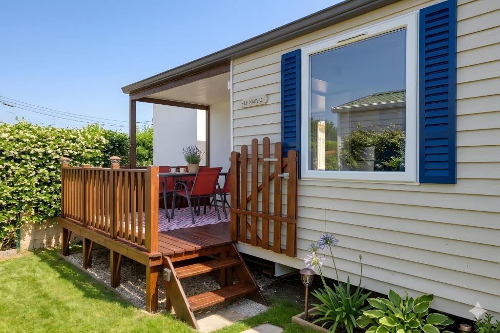 a deck with a table and chairs on a house at Location Mobile home in Marseillan