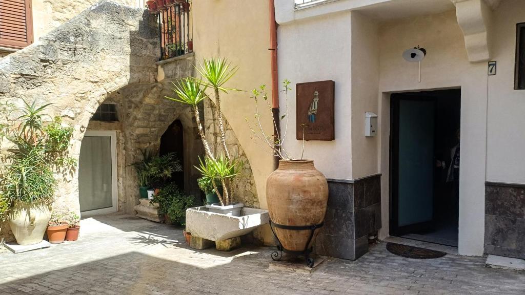 a large vase sitting next to a building with potted plants at Cupola Blu in Ragusa