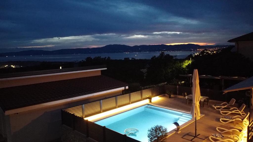 a swimming pool on top of a building at night at Apartman Dora in Šmrika