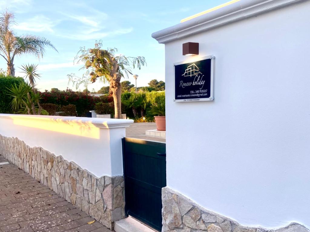 a sign on the side of a white building at Romano Holiday 3 in Marina di Pescoluse