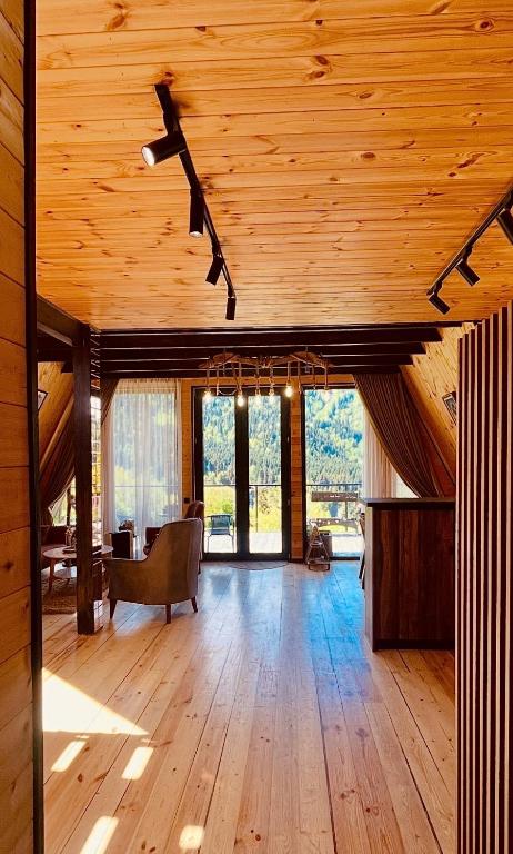 a large room with a wooden ceiling with windows at Mtis Racha in Oni
