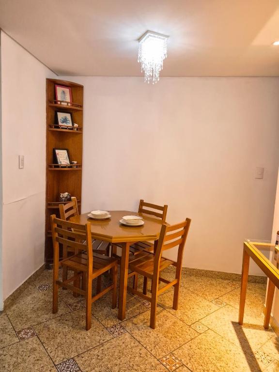a dining room with a wooden table and chairs at Flat Região Central 2 in Barbacena