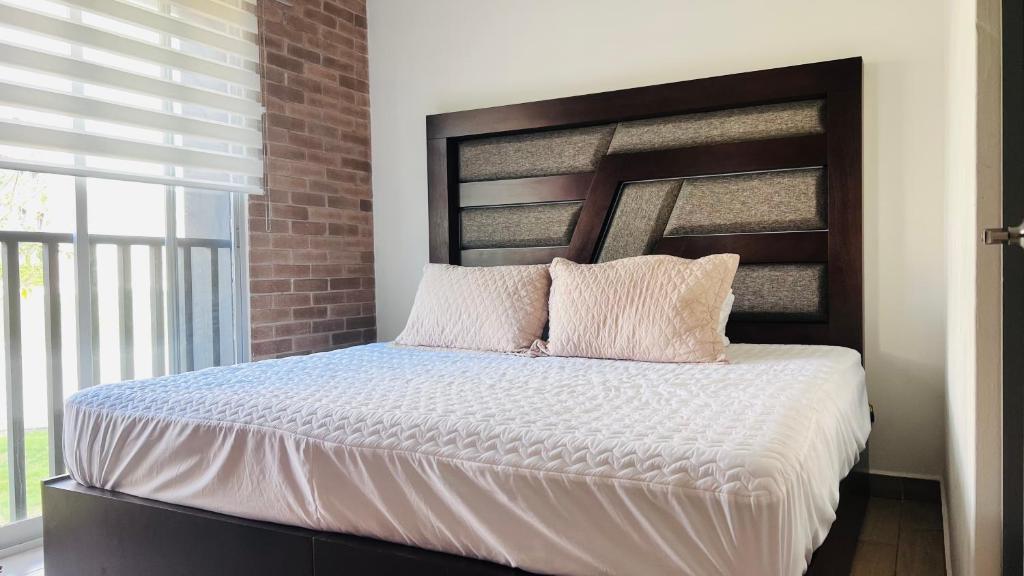 a bedroom with a large bed with a brick wall at Torre 23 in Oaxaca City