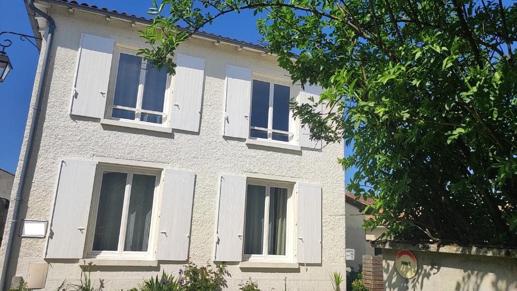 a white building with white shutters on it at Demeure Olea, Chambres D'hôtes in Chérac