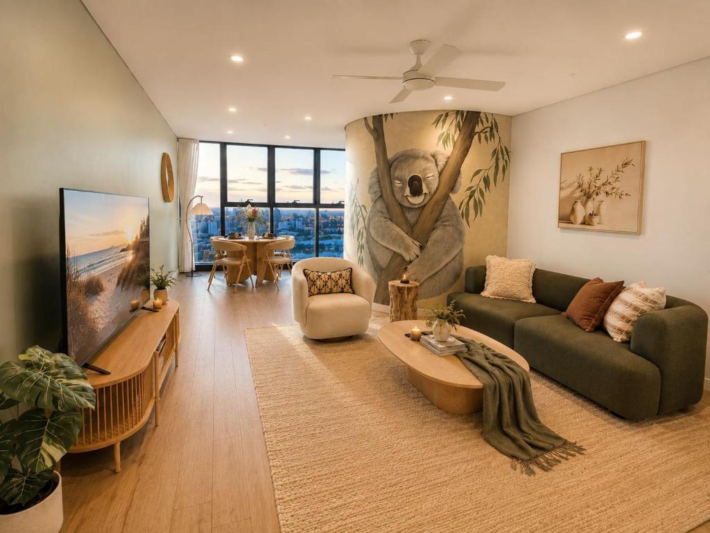 a living room with a couch and a tv at Koala Sky Suite River & City Views in Brisbane
